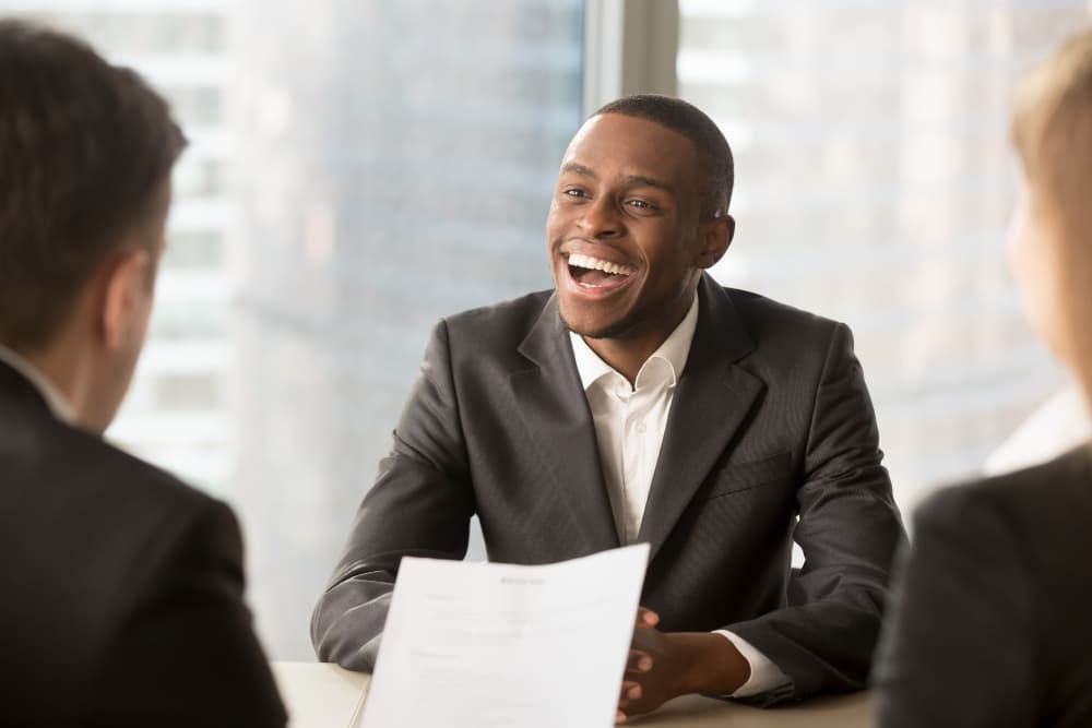 Smiling candidate in a job interview across the table from two interviewers